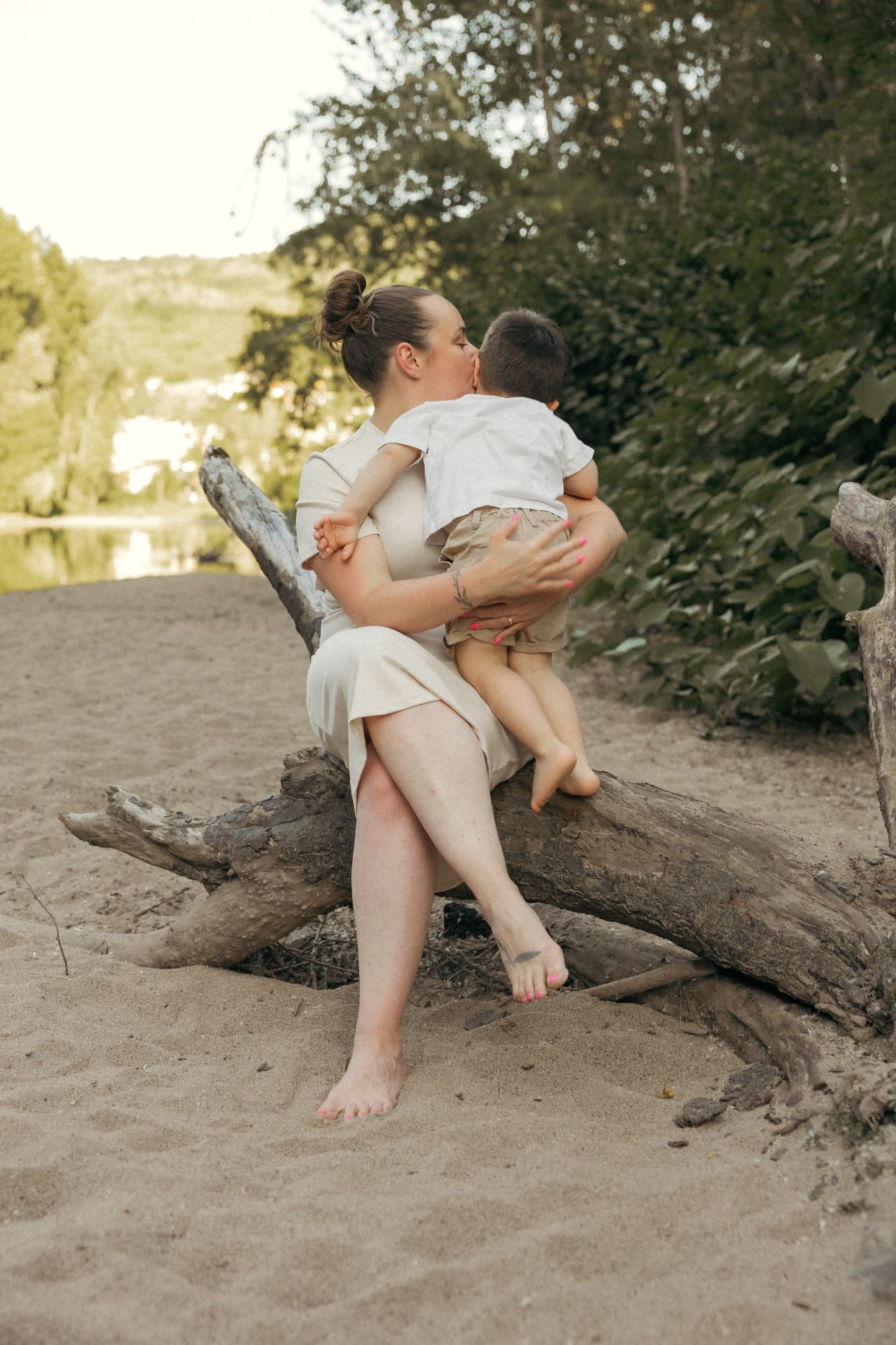 Nolwenn serrant tendrement son fils Milan dans ses bras, au bord d'une rivière